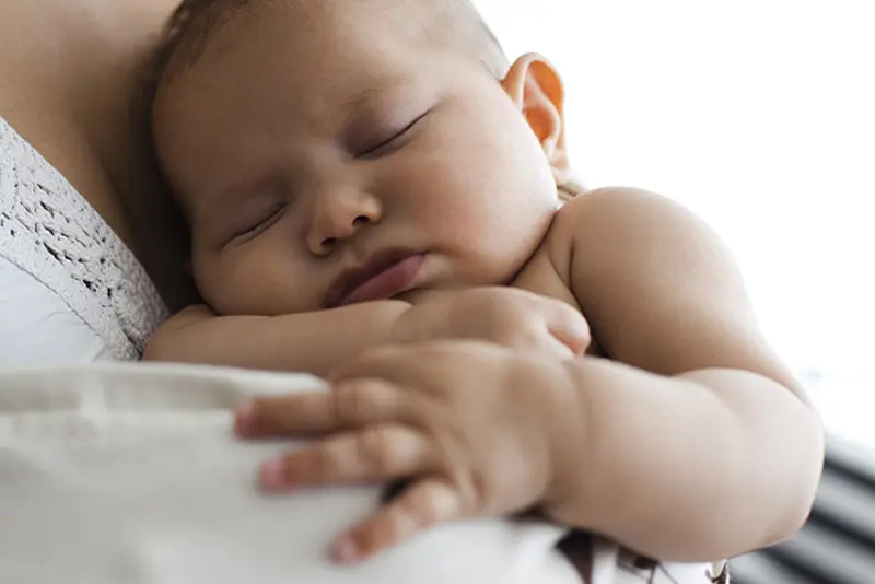 Baby som sover på skulderen