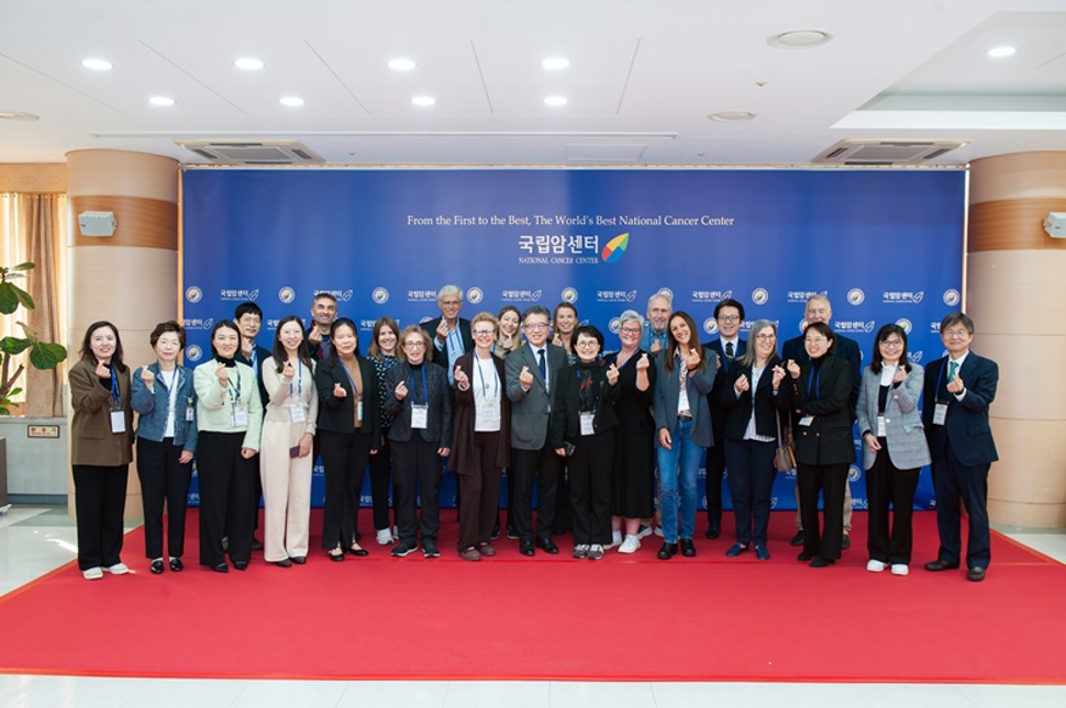 Picture of app. 30 attendants on red carpet and blue background